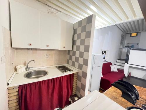 a small kitchen with a sink and a red chair at Stella Marina Appartamento in Cagliari
