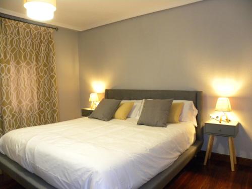 una camera da letto con un grande letto bianco con due lampade di Refugio del cañon a Ucero