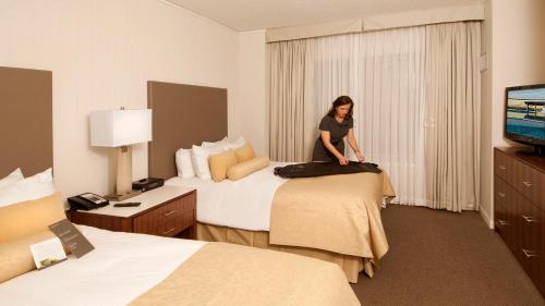 a woman standing on a bed in a hotel room at InterContinental Suites Hotel Cleveland, an IHG Hotel in Cleveland