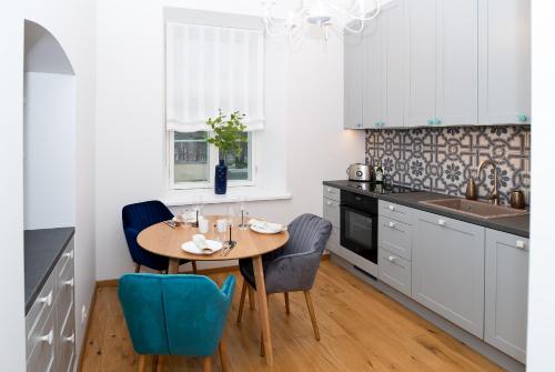 uma cozinha com uma mesa de madeira e cadeiras azuis em Lossi 32 Luxury Apartment with Sauna em Tartu