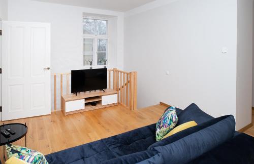uma sala de estar com um sofá azul e uma televisão de ecrã plano em Lossi 32 Luxury Apartment with Sauna em Tartu