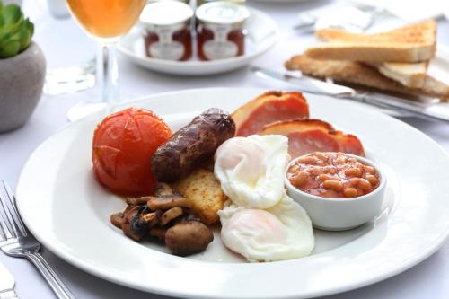 a plate of breakfast food with eggs sausage beans and bread at Best Western Claydon Hotel in Ipswich