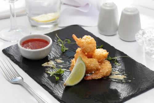 a black plate of food with a lime and sauce at Best Western Claydon Hotel in Ipswich