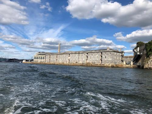 a building on the water with a boat in the water at Clarence at Royal William Yard in Plymouth