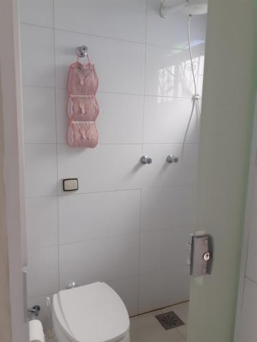 a white bathroom with a toilet and a shower at Pousada Acolhedora in Ribeirão Preto