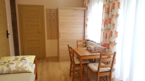 d'une salle à manger avec une table, des chaises et une fenêtre. dans l'établissement Willa Monika Zieleniec, à Duszniki-Zdrój