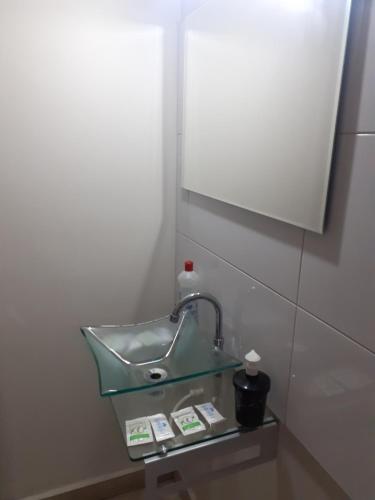a sink in a bathroom with a mirror at Pousada Acolhedora in Ribeirão Preto