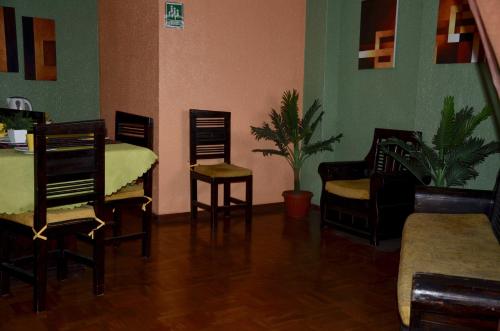 a living room with chairs and a table and a couch at Hostal La Estación Quito in Quito