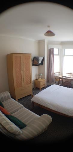 sypialnia z łóżkiem i kanapą w obiekcie 6 berth ground floor flat Glen Villa 2 w mieście Great Yarmouth