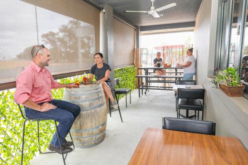 Un hombre sentado en un barril en un restaurante. en Robinvale Bridge Motel, en Robinvale 
