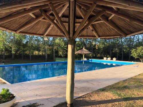ein Holzschirm neben einem Swimmingpool in der Unterkunft Cabañas La Querencia 2 dormitorios in Villa Cura Brochero
