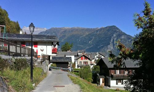 a street in a village with mountains in the background at Les Soldanelles in Salvan