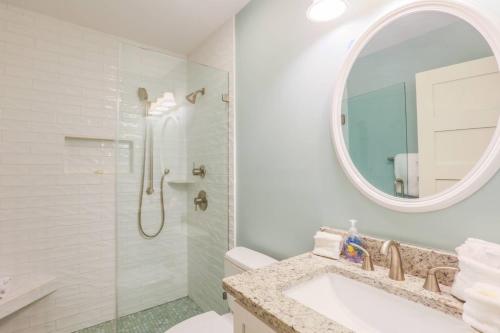 ein Badezimmer mit Dusche, Waschbecken und Spiegel in der Unterkunft Sea La Vie in Kiawah Island