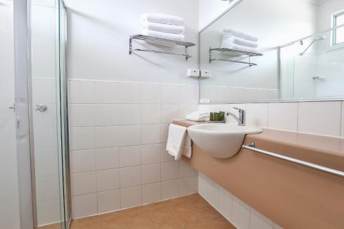 a white bathroom with a sink and a shower at Robinvale Bridge Motel in Robinvale 