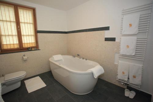 a bath tub sitting next to a toilet in a bathroom at Grad Strmol in Cerklje na Gorenjskem