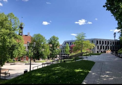 a park in front of a building with trees and benches at Lossi 32 Luxury Apartment with Sauna in Tartu