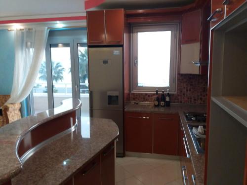 uma cozinha com armários castanhos e uma grande janela em DREAM APARTMENT Vlore em Vlorë