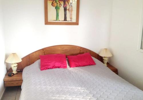 une chambre avec un lit avec deux oreillers rouges dans l'établissement Maison charmante à San-Nicolao avec piscine partagée, à San-Nicolao