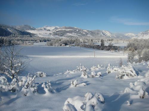 a snow covered field with a lake and mountains at Sun Mountain Lodge in Winthrop