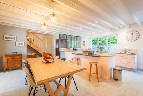 a kitchen and dining room with a wooden table at Rêves d'Autise in Nieul-sur-lʼAutise