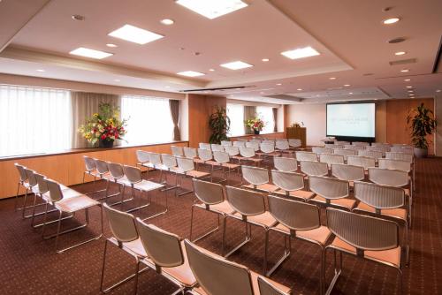 an empty room with chairs and a projection screen at International Garden Hotel Narita in Narita