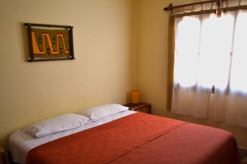 a bedroom with a bed with a window and avertisement at Kamay Apart Cafayate in Cafayate