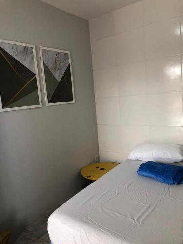a bedroom with a bed and two pictures on the wall at Nomads Hostel Multicultural & Coworking in Salvador