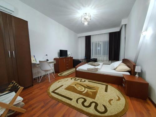 Un dormitorio con una cama y una alfombra en el suelo. en Bonton Rooms, en Târgu Jiu