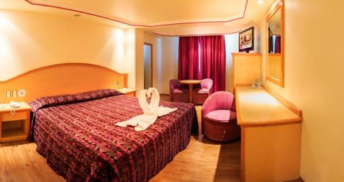 Una cama o camas en una habitación de Hotel Revolución