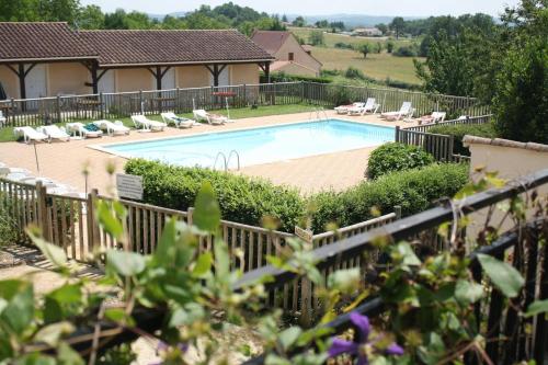 una piscina in un cortile con sedie a sdraio di Hôtel Chastrusse a Nadaillac-de-Rouge