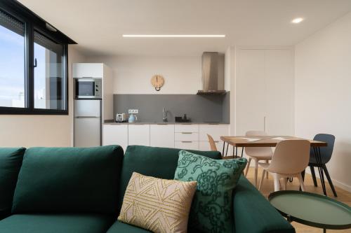 ein Wohnzimmer mit einem grünen Sofa und einem Tisch in der Unterkunft Chez Abel in Las Palmas de Gran Canaria