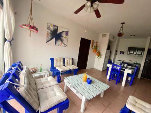 a living room with blue chairs and a table at Casa CARIBE Cancun in Cancún