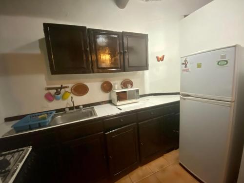 a kitchen with a white refrigerator and a sink at Casa CARIBE Cancun in Cancún