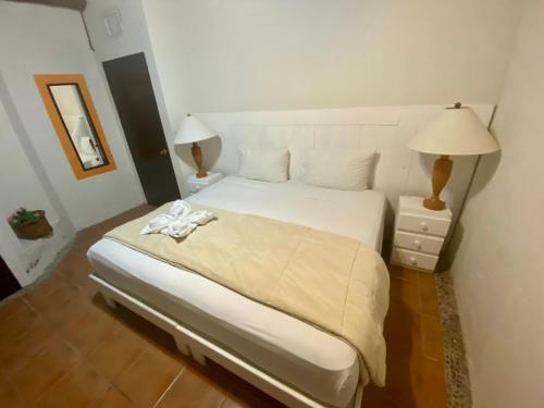1 dormitorio con 1 cama blanca grande y 2 lámparas en Casa CARIBE Cancun, en Cancún