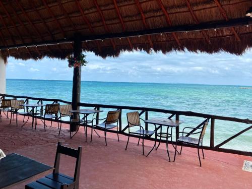 a row of tables and chairs on the beach at Casa CARIBE Cancun in Cancún