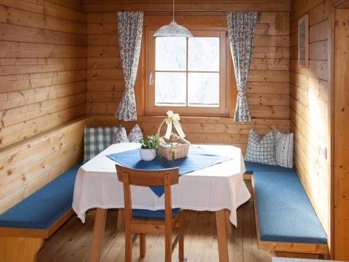 une salle à manger avec une table et une fenêtre dans l'établissement Elsenhof, à Hopfgarten in Defereggen