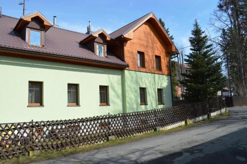 a house with a fence in front of it at Penzion 103 in Železná Ruda