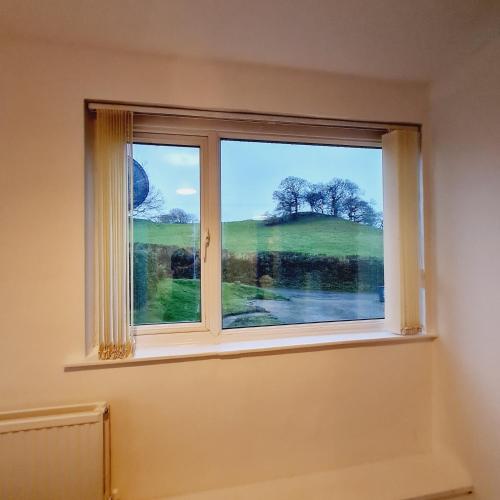 a window with a view of a green field at Daron Large Country Cottage in Llansannan