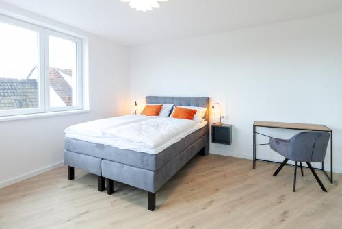 a white bedroom with a large bed and a desk at STAY@MA Boardinghouse Mannheim in Mannheim
