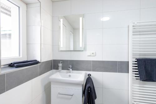 a white bathroom with a sink and a mirror at STAY@MA Boardinghouse Mannheim in Mannheim
