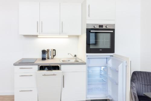 a white kitchen with a sink and a microwave at STAY@MA Boardinghouse Mannheim in Mannheim