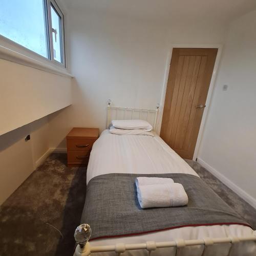 a bedroom with a large bed with a window at Daron Large Country Cottage in Llansannan