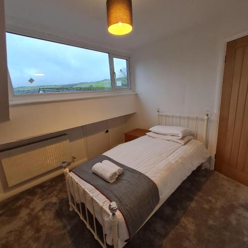 a bedroom with a bed and a large window at Daron Large Country Cottage in Llansannan