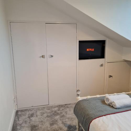 a bedroom with a bed and a tv on a wall at Daron Large Country Cottage in Llansannan