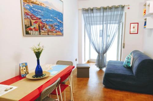 un soggiorno con tavolo e divano blu di La Casita Toledo - In pieno centro a Napoli