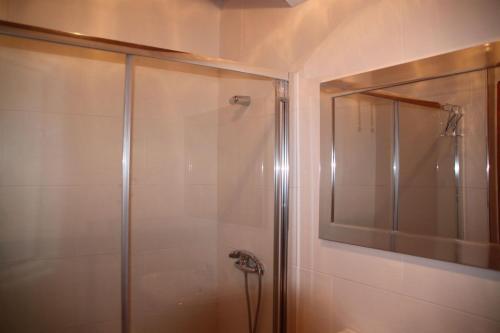 een badkamer met een douche met een glazen deur bij Casas do Patrao II in Sabugueiro