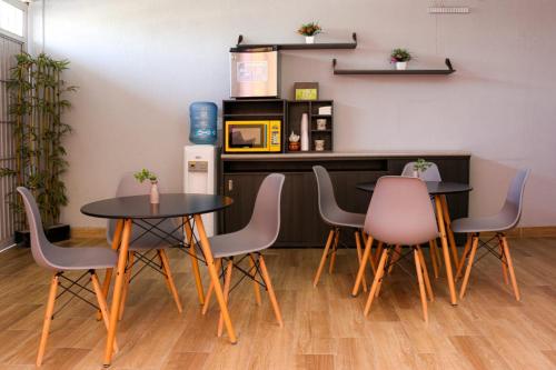 Suites Bajío في ليون: غرفة طعام مع طاولتين وكراسي