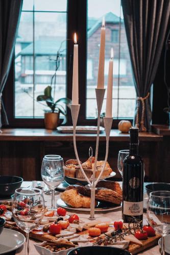 a table with a plate of food and a bottle of wine at Holiday Home Drinsko svitanje in Gornja Trešnjica