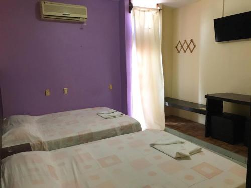 a hotel room with two beds and a window at Hotel Frailes in Arriaga