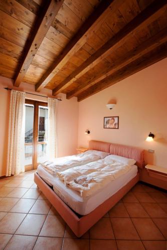 a bedroom with a large bed with a wooden ceiling at Residence Erika in Tignale